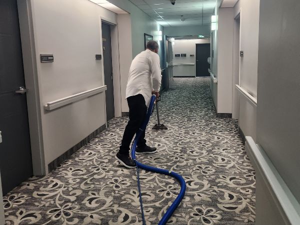 Canadian Janitorial Services cleaning a hallway carpet